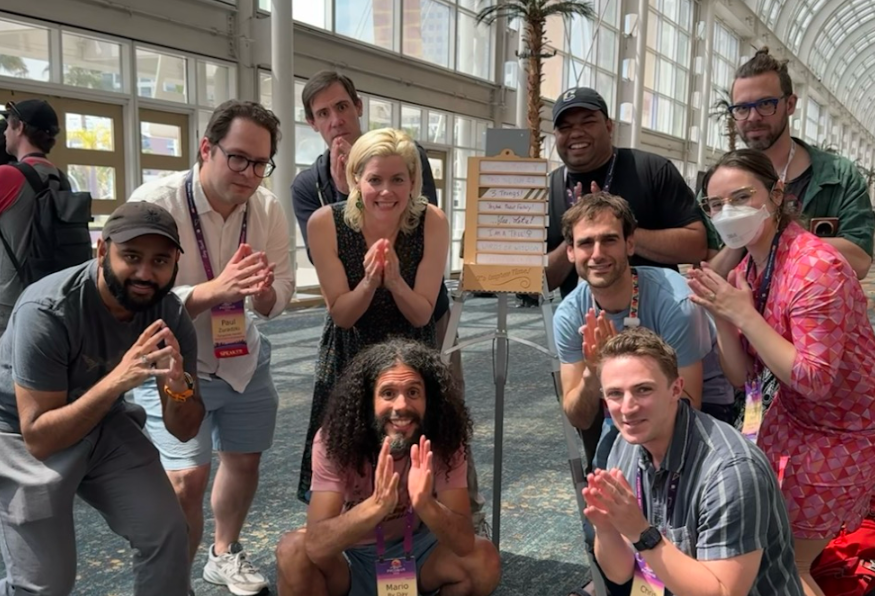 A group of conference attendees posing together after playing an improv game.